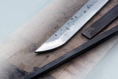 Katana kılıç yapımı. Bıçak ve tahta yüzeydeki çelik prezervatifler.
