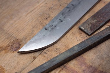Katana kılıç yapımı. Bıçak ve tahta yüzeydeki çelik prezervatifler.