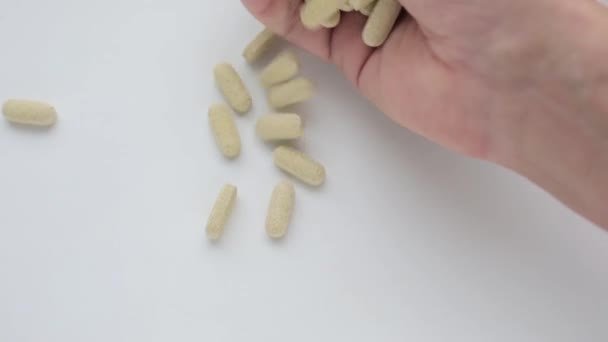 Pillen mit pflanzlichen Vitaminen werden aus der Hand gegeben.