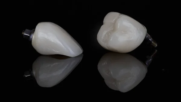 Two Beautiful Dental Crowns Chewing Front Teeth Black Glass Reflection Imagen de archivo