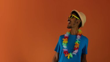 Brezilya karnavalı için kostüm giyen siyah adam turuncu arka planda izole edilmiş.. 