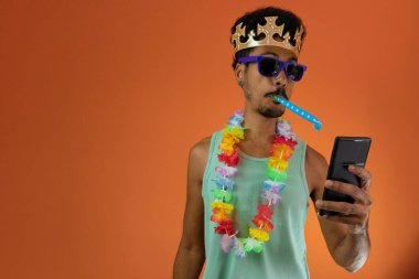 Karnaval için kostüm giymiş, elinde cep telefonu olan siyah bir adam.. 