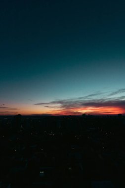 Şehrin siluetiyle yükselen güneş silueti silueti. 