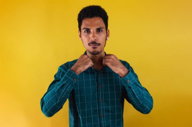 Stüdyoda takım elbiseli siyah bir adam sarı arka planda izole edilmiş..