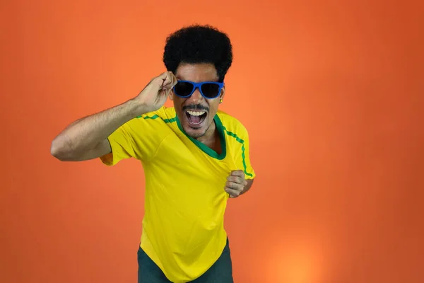 Fotbalový Brazilský Fanoušek Slaví Izolované Oranžovém Pozadí Nadšený Fotbalový Fanoušek — Stock fotografie