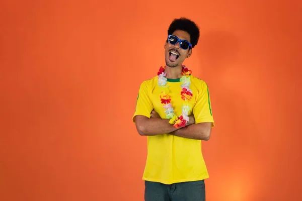 黄色のサッカー衣装の男はオレンジの背景に孤立を祝う — ストック写真