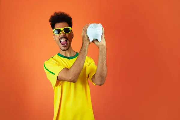 Jogador Futebol Homem Negro Celebrando Segurando Porco Moeda Isolada Laranja — Fotografia de Stock