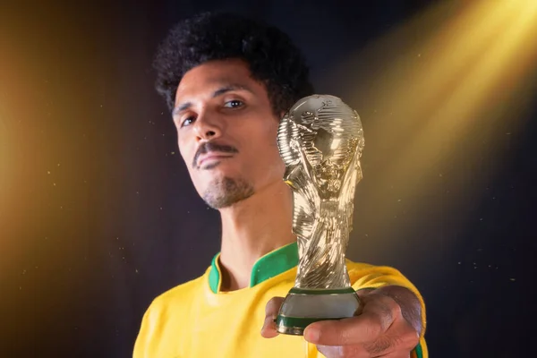 ブラジルのサッカーブラック選手は黒の背景に隔離され 優勝トロフィーとお祝いを保持 — ストック写真