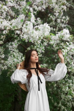 Çiçek açmış bir elma ağacının dallarında bir kadının portresi. Güzel doğal makyaj.