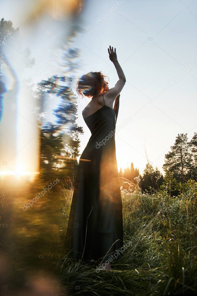 Portrait  beautiful woman in forest at sunset. Woman is resting in nature, an art portrait in the rays of the sun