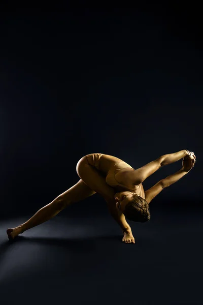 Yoga woman gold body, spiritual and physical practices. Judaism exercises body and soul.  Fitness woman yoga. Healthy life and natural balance between body and mental development. Black background