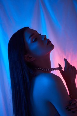 Stüdyoda güzel bir kadın var. Neon ışıklı özgürlük konseri. Vücut hatununda moda tarzı hafif elbise