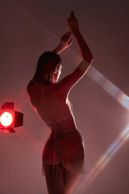 Art Beauty çıplak seksi kadın neon ışığı stüdyoda poz veriyor. Bir kadının makyaj portresi. Zayıf, mükemmel vücut, erotik poz, seksi mücevherler.