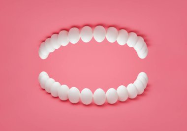Pembe arka planda insan protezi olarak yerleştirilmiş tavuk yumurtalı konsept fotoğraf. Tavuk yumurtasından yapılan insan dişlerinin kopyası..