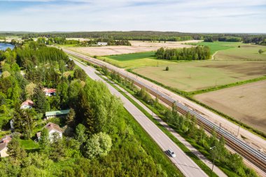 Finlandiya 'nın Kouvola kentindeki Myllykoski' de havadan panoramik yol, yol ve demiryolu manzarası.