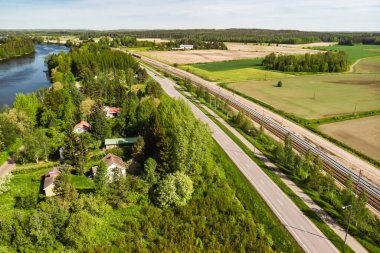 Finlandiya 'nın Kouvola kentindeki Myllykoski' de havadan panoramik yol, yol ve demiryolu manzarası.