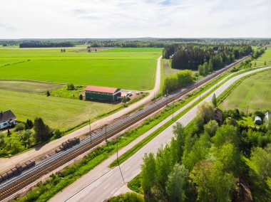 Finlandiya 'nın Kouvola kentindeki Myllykoski' de havadan panoramik yol, yol ve demiryolu manzarası.