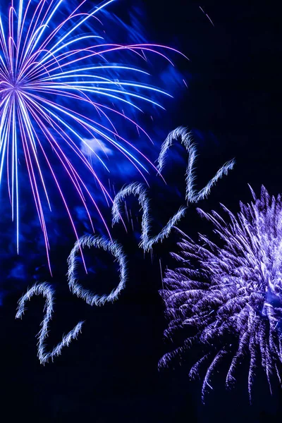 Mutlu yıllar 2022. 2022 yılında siyah arka planda havai fişeklerle parlayan yanma sayıları.