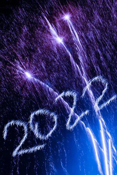 Mutlu yıllar 2022. 2022 yılında siyah arka planda havai fişeklerle parlayan yanma sayıları.