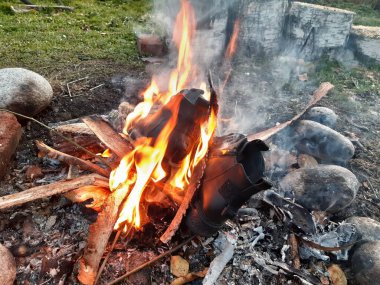 Şenlik ateşinde iki siyah ayakkabı yanıyor.