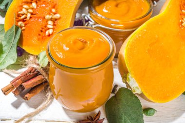 Tatlı kabak turtası reçeli. Ev yapımı balkabağı püresi ve geleneksel sonbahar baharatları. Tarçın, anason. Taze tereyağlı ezme ve dökülen yapraklarla beyaz ahşap arka planda