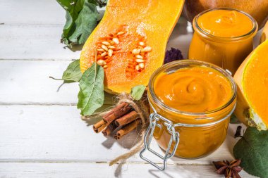 Tatlı kabak turtası reçeli. Ev yapımı balkabağı püresi ve geleneksel sonbahar baharatları. Tarçın, anason. Taze tereyağlı ezme ve dökülen yapraklarla beyaz ahşap arka planda