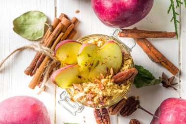 Sonbahar elmalı cevizli yulaf ezmesi, kırmızı elmalı yulaf lapası, cevizli fındık ve karamel sosu, beyaz ahşap arka plan fotokopi alanı.