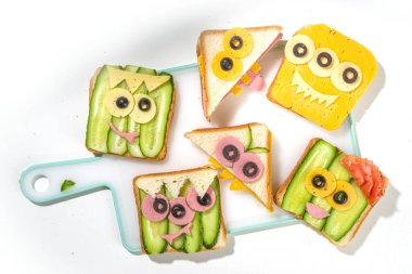 Çeşitli komik canavar Cadılar Bayramı sandviçleri. Çeşitli yaratıcı kahvaltı atıştırmalıklarını peynirli tostları, Cadılar Bayramı çocuklarının parti yemeklerini, üst manzarayı ayarlayın. 