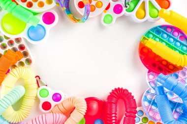 Modern trend çocuklar parmak oyuncakları, rahatlama konsepti - beyaz arka planda farklı parlak pop-it setleri, basit gamzeli, yumuşak, pop-tüpleri, üst görünüm kopyalama alanı