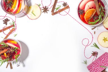 Ev yapımı sıcak şarap kokteyli. Klasik kış baharatlı sıcak sıcak sıcak şaraplı çeşitli cam bardaklar, beyaz arka plandaki malzemeler üst görünüm kopya alanı