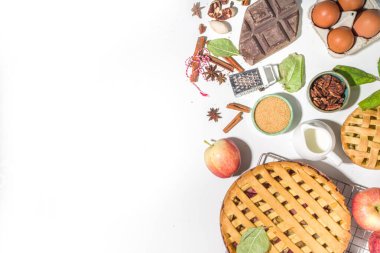 Sonbahar pastası ve kek pişirme arka planı. Tatlı elma, ceviz, kabak kabağı turtaları fırın malzemeleri ve çatal bıçakları, beyaz masa arkaplanı fotokopi alanı