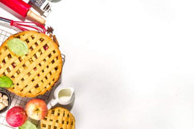 Sonbahar pastası ve kek pişirme arka planı. Tatlı elma, ceviz, kabak kabağı turtaları fırın malzemeleri ve çatal bıçakları, beyaz masa arkaplanı fotokopi alanı