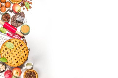 Sonbahar pastası ve kek pişirme arka planı. Tatlı elma, ceviz, kabak kabağı turtaları fırın malzemeleri ve çatal bıçakları, beyaz masa arkaplanı fotokopi alanı
