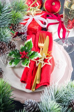 Tabaklar, şampanya kadehleri, Noel hediye kutuları ve süslemeler, köknar ağacı dalları, siyah beton arka plan fotokopi alanı üst görünümü