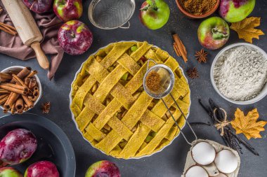 Sonbahar elmalı turta pişirme geçmişi. Çiğ geleneksel elmalı turta, fırın malzemeleri ve çatallar, siyah beton arka plan kopyalama alanı ile pişirme arka planı 