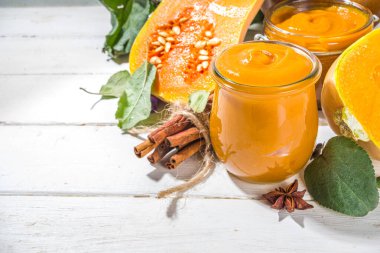 Tatlı kabak turtası reçeli. Ev yapımı balkabağı püresi ve geleneksel sonbahar baharatları. Tarçın, anason. Taze tereyağlı ezme ve dökülen yapraklarla beyaz ahşap arka planda