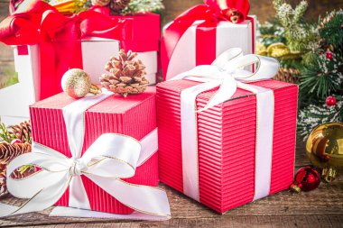 Noel tebrik kartı geçmişi. Bir sürü kırmızı ve beyaz hediye kutusu, şenlik kurdeleleri, noel süsleri ve tahta arka planda