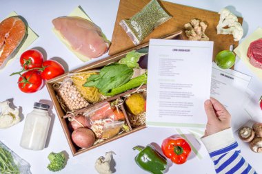 Yemek seti teslimat konsepti. Çeşitli sağlıklı yemek malzemeleri koyun et, sebze, meyve, baharat ve yemek tarifleri. İnternetten şef malzemeleri sipariş etmek, market teslimatı.