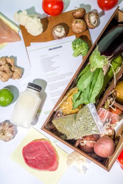 Yemek seti teslimat konsepti. Çeşitli sağlıklı yemek malzemeleri koyun et, sebze, meyve, baharat ve yemek tarifleri. İnternetten şef malzemeleri sipariş etmek, market teslimatı.