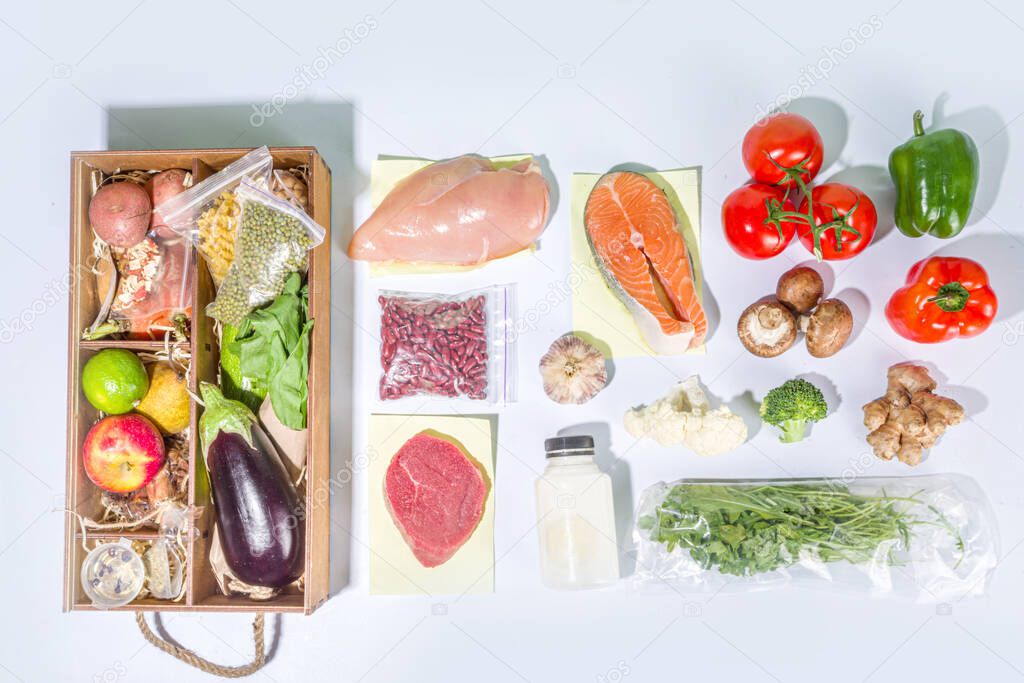 Meal Kit Delivery Concept. Set various healthy dishes food ingredients meat, vegetables, fruit, spices with recipes for cooking. Online ordering chef foods ingredients, grocery delivery