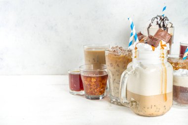 Farklı buzlu yaz kahve içecekleri - espresso, frappe, latte, cappuccino, kremalı, şuruplu ve ezilmiş buzlu, çeşitli bardaklarda ve kupalarda beyaz arka planda fotokopi alanı
