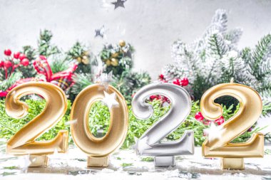 2022 yılbaşı tebrik kartı geçmişi, 2022 bayram mumlu bayrak, gümüş yıldız dekor, Noel ağacı dalları ve yapay kar.