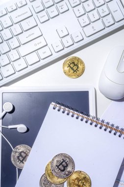 Ofis masaüstü çalışma alanındaki bitcoin paralar. Kripto para piyasası konseptiyle çalışmak. Klavye, dizüstü bilgisayar, tablet, fare, büyüyen bitcoin oranının grafikleri beyaz ofis masasında, üst görünüm kopyalama alanı