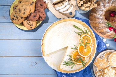 Ev yapımı Noel pastaları, pudra şekerli tatlı cheesecake turtası, portakal ve biberiye. Noel ve Yeni Yıl şenlikli pişirme geçmişi