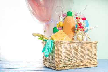 Bahar temizliği konsepti. Güneş, açık pencerenin yanındaki arka planda kova ya da sepette temizlik malzemeleri, şişeler, ekipmanlar ve malzemeler vardı. Ev temizliği, hijyen, ev işleri konsepti.