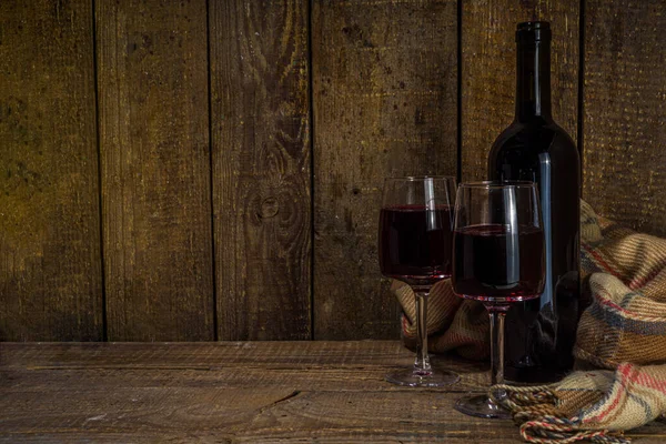 冬のワインの試飲の低迷の背景 居心地の良いプレイと冬の装飾のコピースペースと木製の背景に2つのガラスとクラフトワインボトル — ストック写真