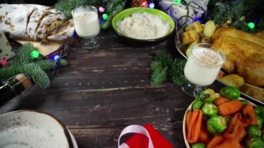 Geleneksel yiyeceklerle, fırınlanmış jambonla, tavukla, kızarmış havuçla, Brüksel lahanasıyla, patatesle, Noel dekoruyla ve hediyelerle dolu Noel yemeği masası. 