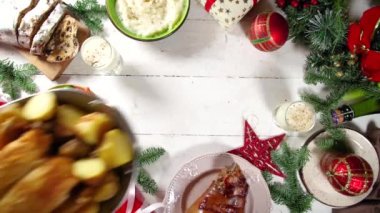 Geleneksel yiyeceklerle, fırınlanmış jambonla, tavukla, kızarmış havuçla, Brüksel lahanasıyla, patatesle, Noel dekoruyla ve hediyelerle dolu Noel yemeği masası. 