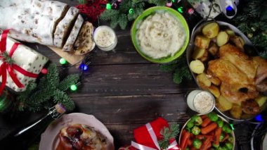 Geleneksel yiyeceklerle, fırınlanmış jambonla, tavukla, kızarmış havuçla, Brüksel lahanasıyla, patatesle, Noel dekoruyla ve hediyelerle dolu Noel yemeği masası. 