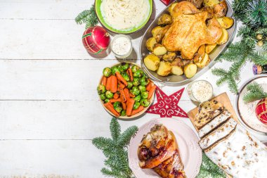 Geleneksel yiyeceklerle, fırınlanmış jambonla, tavukla, kızarmış havuçla, Brüksel lahanasıyla, patatesle, Noel dekoruyla ve hediyelerle dolu Noel yemeği masası.